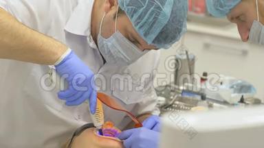 牙医正在现代牙科诊所治疗病人。 正畸医生与一名助手合作。 病人是